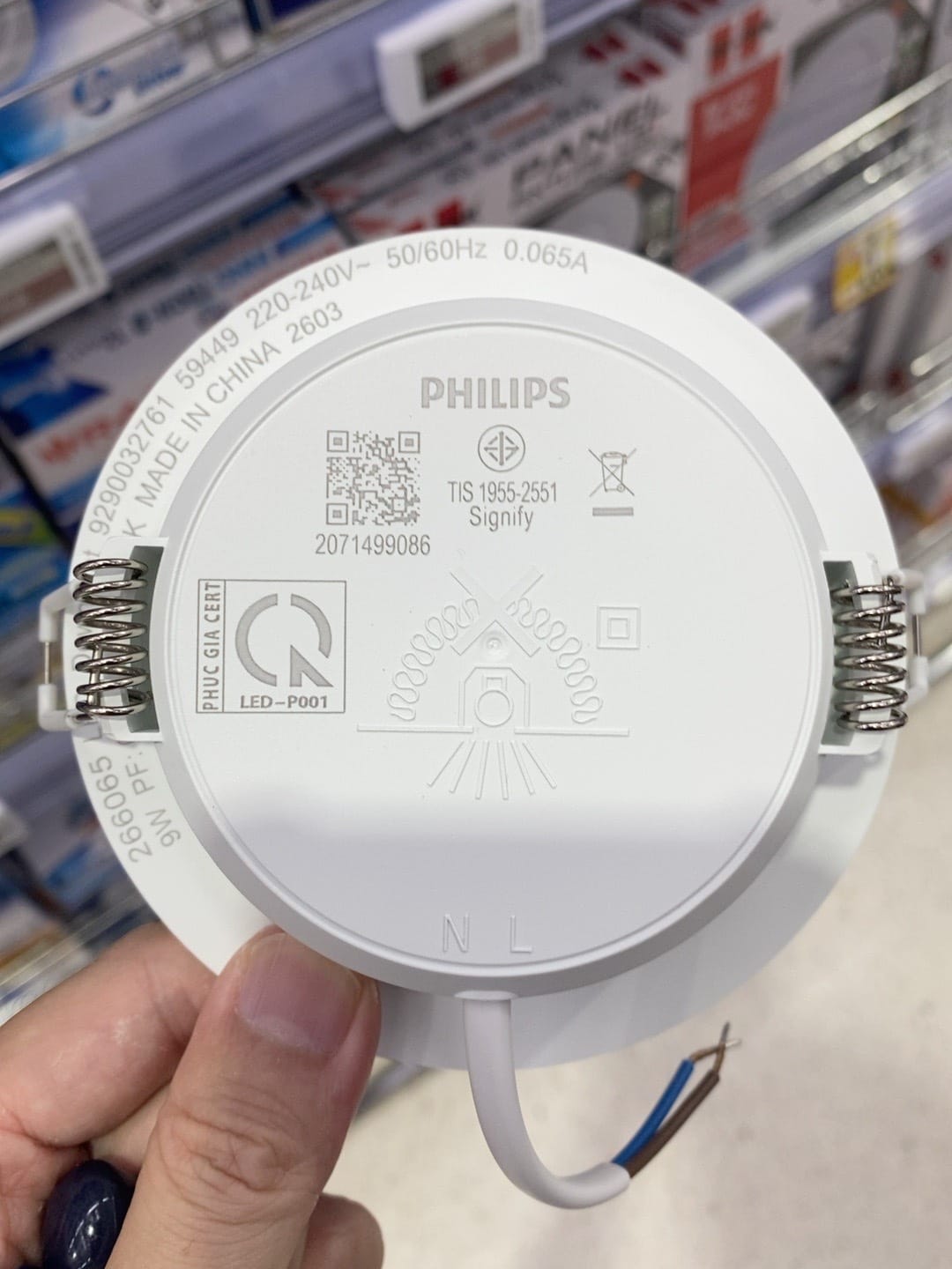 The back of the new Philips downlight held in the shop aisle, showing 220-240V, 0.065A, spring clips and two bare wires marked N and L