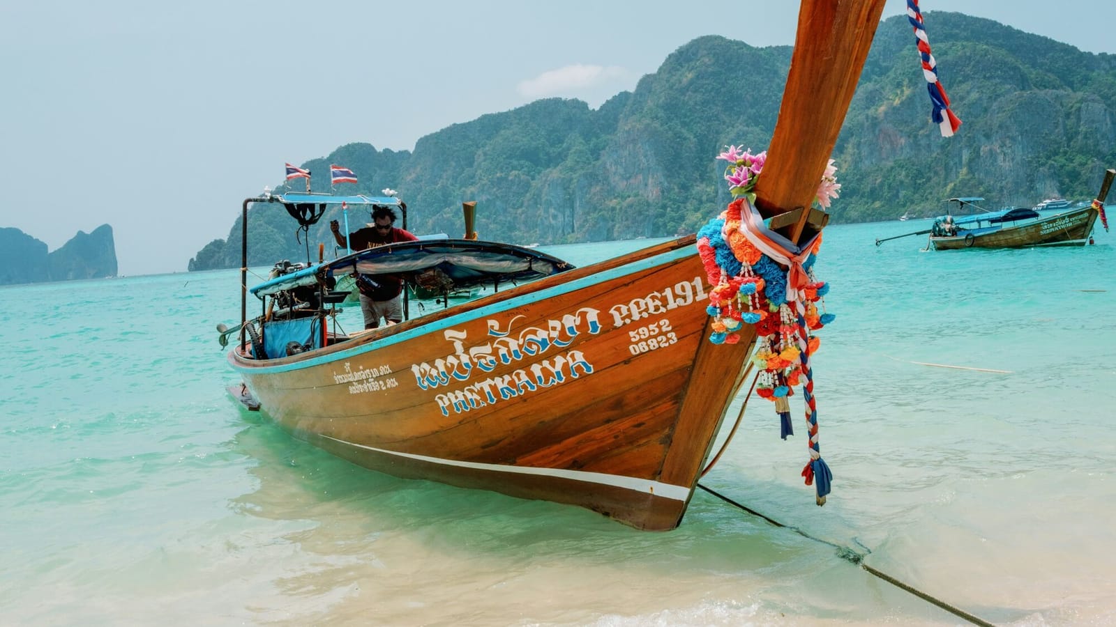 A Thai longtail boat pulled up on a beach